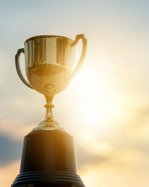 Trophy held up to the sky with sun reflecting off of it.