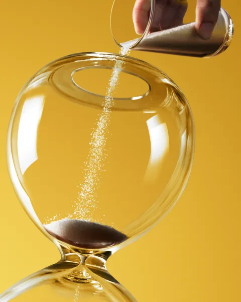 Deadline extended represented by pouring more sand into hourglass.