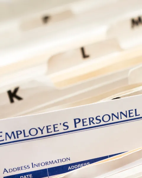 Close-up of tops of file folders with employee personnel files.