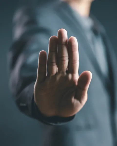 Close-up of a hand in the "stop" or "halt" gesture.