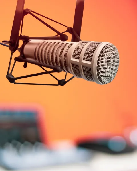 Close-up of a professional microphone and an "ON AIR" sign.