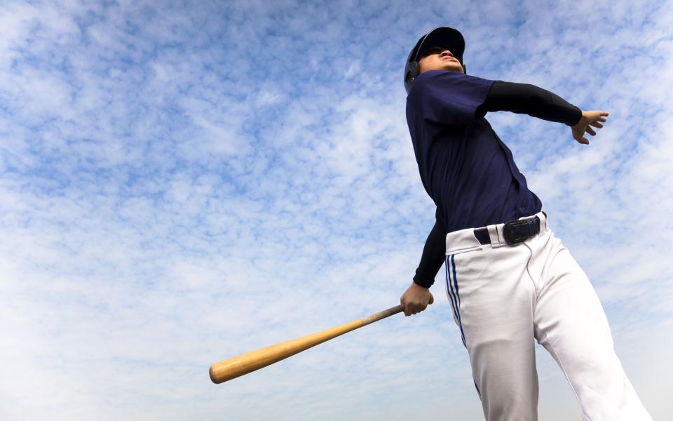 A baseball player swinging while at bat.
