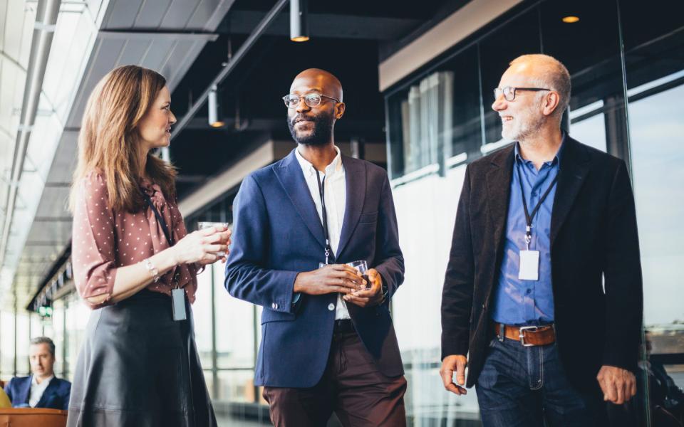 A trio of business colleagues walking and talking.