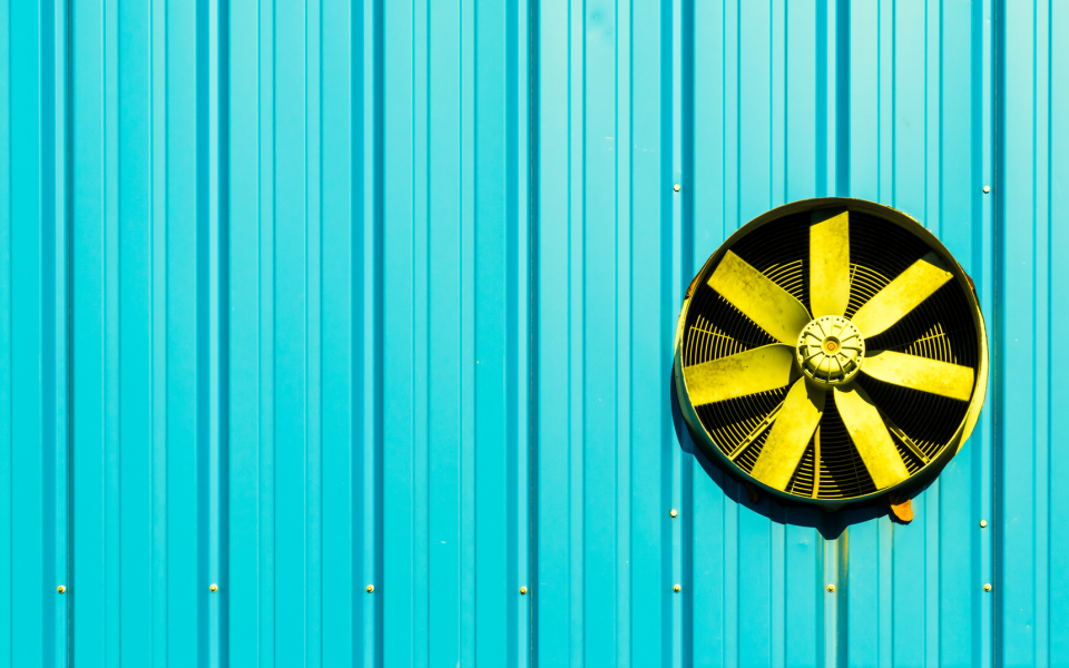 Cooling fan against a bright blue wall