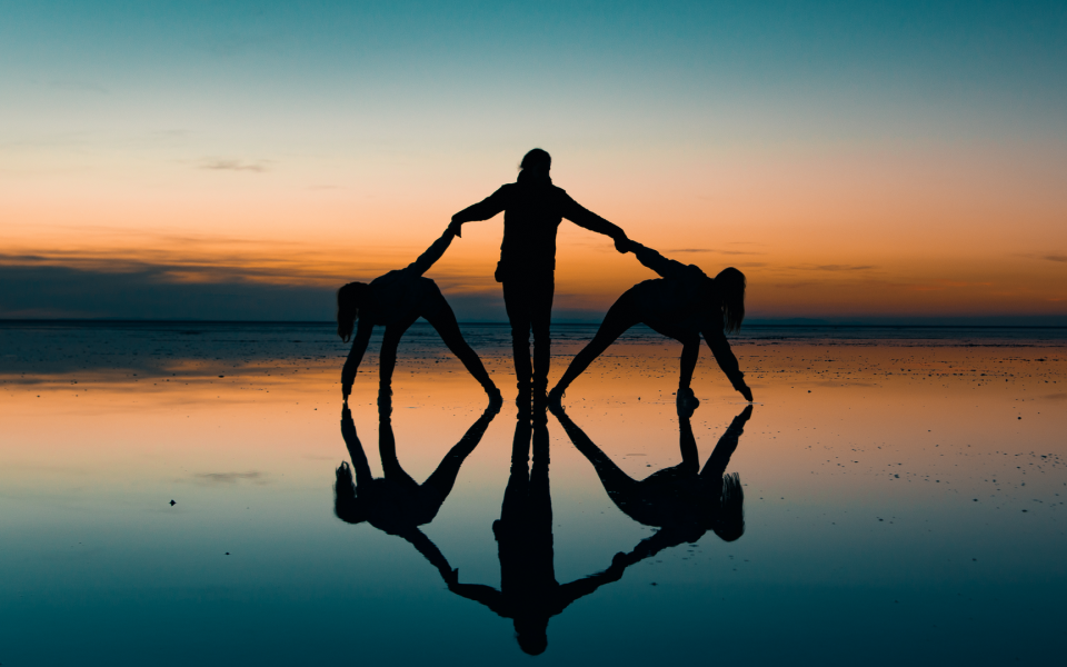 Friends making a circle on a salt flat at dusk