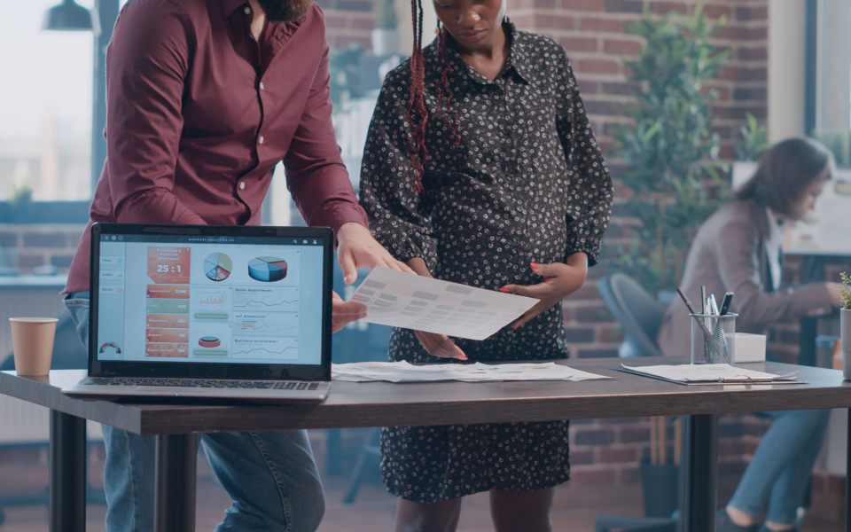 Pregnant person working alongside a colleague