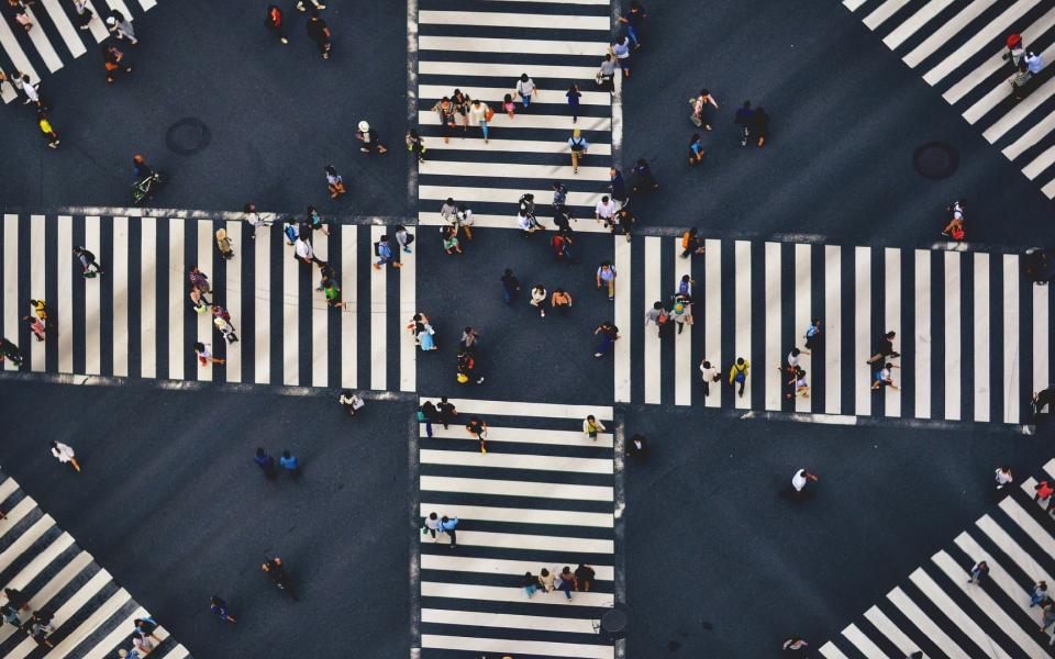 Overhead shot of a crowd walking in a crosswalk.