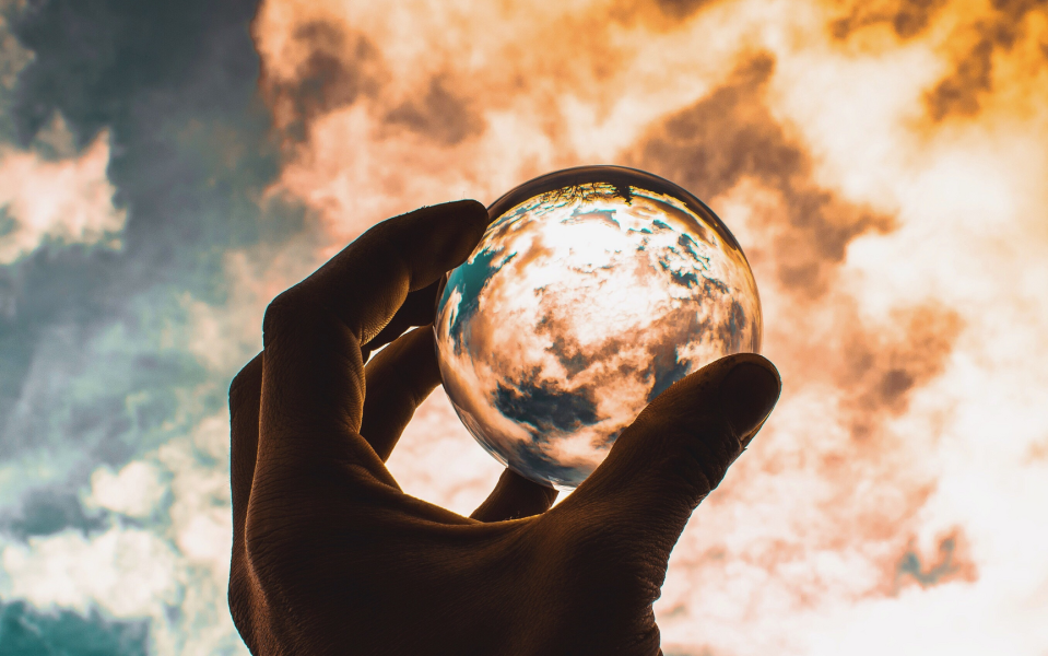 Crystal ball held up to the sky.