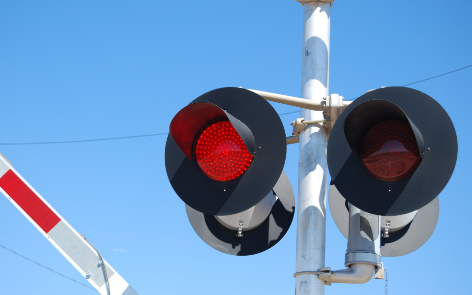 Image of a railroad train signal flashing red/stop.