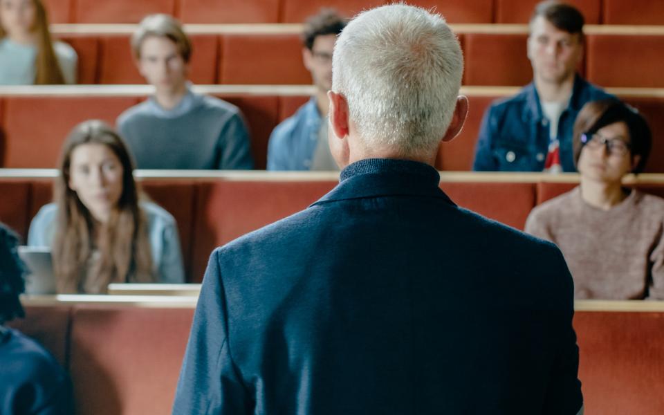 A view fromnthe back of a professor's head as he lectures to his class.