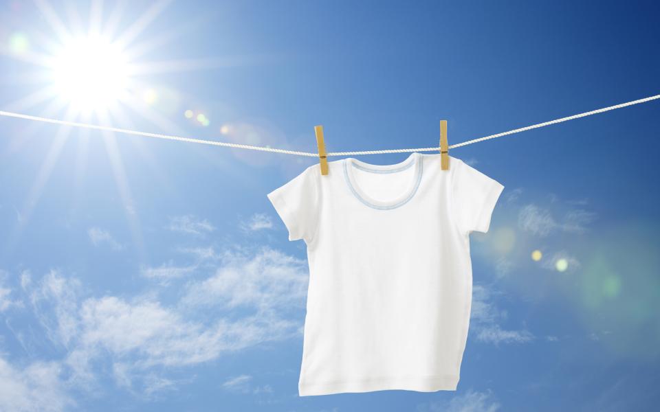 A white T-shirt on clothes line against blue sky.