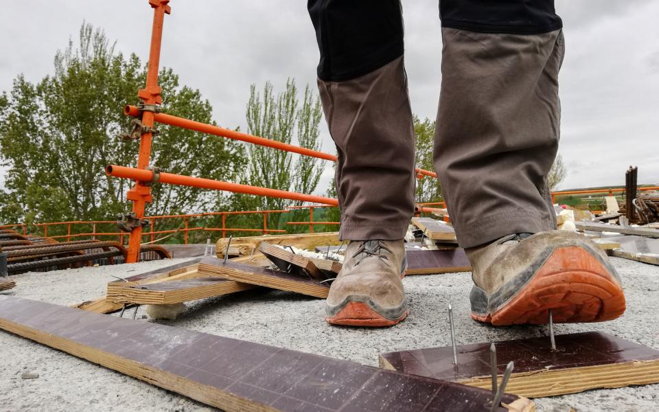 A construction worker has an accident stepping on a nail.