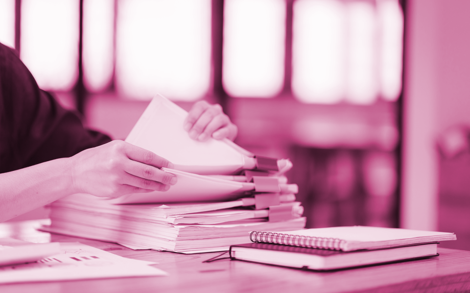 A woman's hands sifting through a file of paperwork.