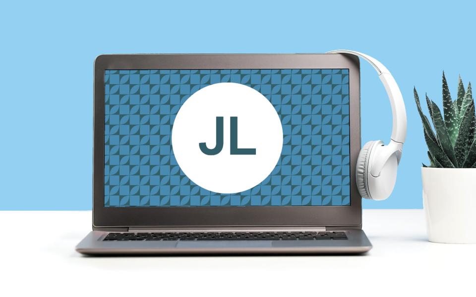 Image of a laptop with a set of headphones on a desk with a topaz blue color scheme.
