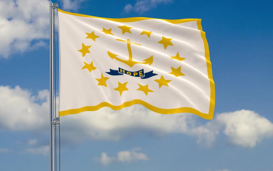 Flag of Rhode Island fluttering in the wind against a cloudy sky.