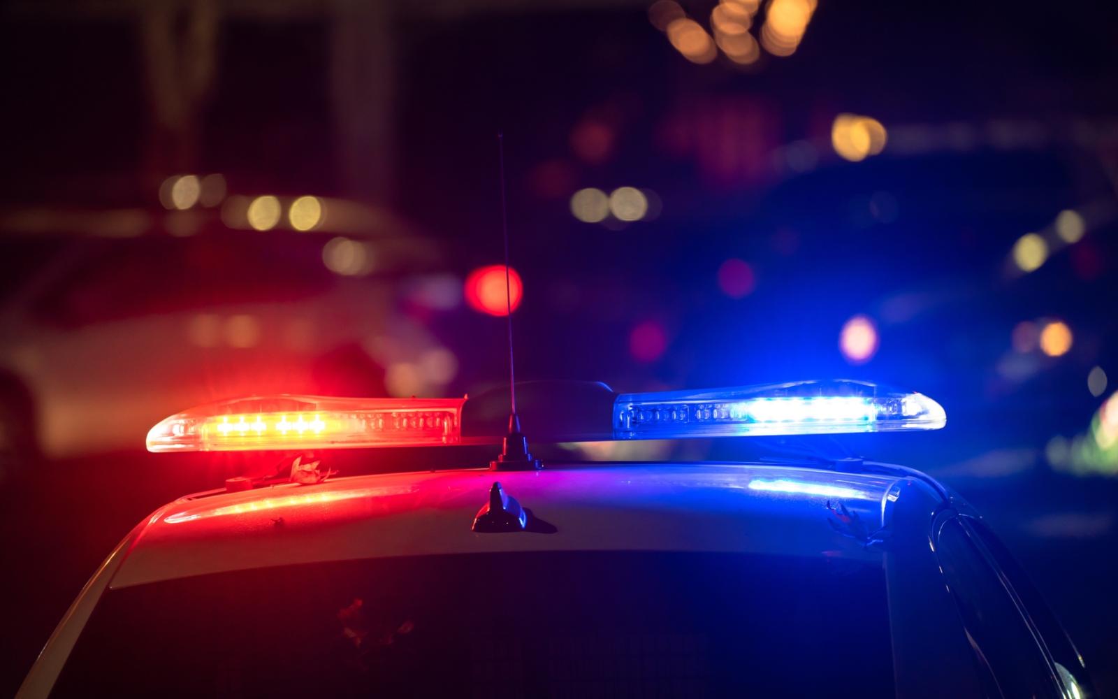 Police car with flashing lights on at night.
