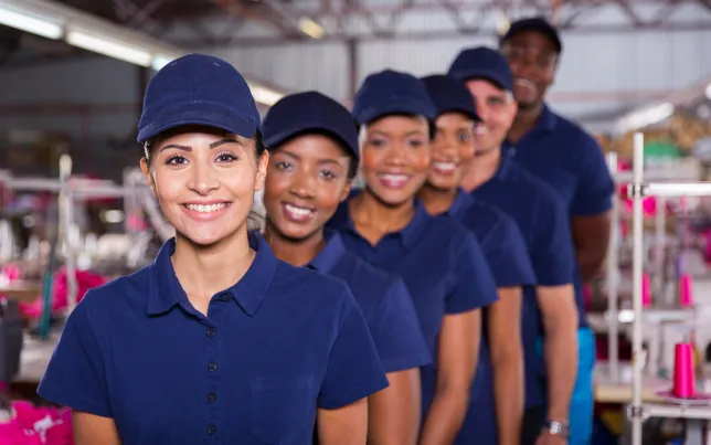 Diverse group of smiling team members wearing matching blue uniforms