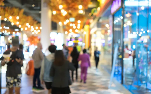A blurred image of a busy mall at the holidays.