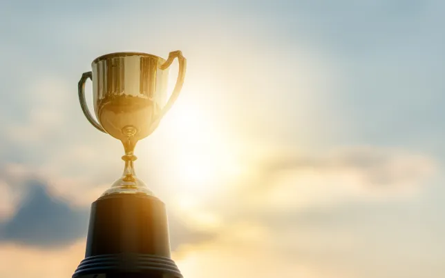 Trophy held up to the sky with sun reflecting off of it.