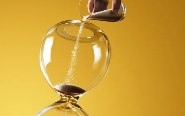 Deadline extended represented by pouring more sand into hourglass.