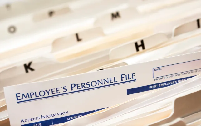 Close-up of tops of file folders with employee personnel files.
