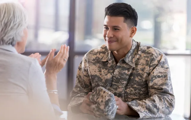 Young male in uniform smiles at counselor.