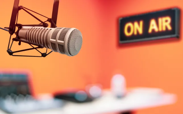 Close-up of a professional microphone and an "ON AIR" sign.