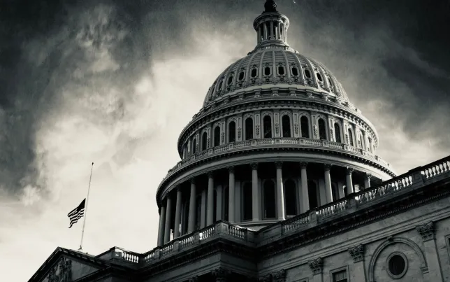 Monochromatic image of a darkened US Capitol building in front of a dark and stormy sky.