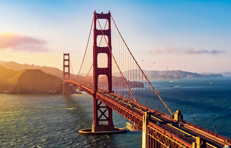Aerial view of the Golden Gate Bridge with sunset in background.